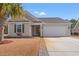 Tan house with green shutters, a two-car garage, and a landscaped yard at 329 Hillsborough Dr., Conway, SC 29526