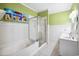 Updated bathroom featuring a combination tub and shower with a glass door, and white cabinets at 489-3 Golden Bear Dr. # 3, Pawleys Island, SC 29585