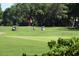 Picturesque golf course with golfers, lush greens, and golf carts under a sunny sky at 489-3 Golden Bear Dr. # 3, Pawleys Island, SC 29585
