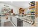 Open kitchen featuring granite countertops, stainless steel appliances, white cabinetry, and built-in shelving at 489-3 Golden Bear Dr. # 3, Pawleys Island, SC 29585