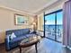 Cozy living room featuring a blue sofa, ocean-themed decor, and balcony access with ocean views at 6900 N Ocean Blvd. # 1234, Myrtle Beach, SC 29577