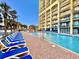 Bright condominium complex showcasing a large in-ground pool and plenty of lounge chairs, set under a clear blue sky at 6900 N Ocean Blvd. # 1234, Myrtle Beach, SC 29577