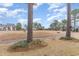 Open grassy area with mature trees and nearby buildings, offering a peaceful community atmosphere at 775 Plantation Dr. # 48, Little River, SC 29566