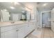 Double vanity bathroom with white cabinets and a large mirror at 8500 Margate Circle # 606, Myrtle Beach, SC 29572