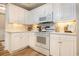 White kitchen with corner cabinetry, electric range and microwave at 8500 Margate Circle # 606, Myrtle Beach, SC 29572