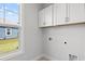 Bright laundry room features white cabinetry, utility connections, and natural light at 10 Grace Bay Ct., Pawleys Island, SC 29585