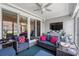 Relaxing screened-in patio boasts stylish furniture, ceiling fan, and sliding glass doors for seamless indoor/outdoor living at 10 Grace Bay Ct., Pawleys Island, SC 29585