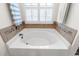 Close up of tiled bathtub with modern fixtures and shuttered window at 113 Preservation Dr., Myrtle Beach, SC 29572
