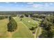 Picturesque aerial view of a lush golf course featuring manicured greens, a tranquil pond, and surrounding residential areas at 141 Foxford Dr., Conway, SC 29526