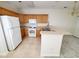 Galley kitchen with oak cabinets, white appliances, and neutral countertops at 155 E Chenoa Dr. # E, Murrells Inlet, SC 29576