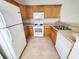 Galley kitchen with oak cabinets, white appliances, and neutral countertops at 155 E Chenoa Dr. # E, Murrells Inlet, SC 29576