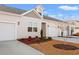 Tan townhome with white garage doors and landscaping at 3518 Bells Lake Circle # 215, Longs, SC 29568