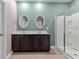 Bright bathroom with a double sink vanity, a framed mirror, and a glass enclosed shower with neutral tile floors at 421 Sunforest Way, Conway, SC 29526