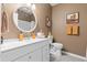Well-lit bathroom features a white vanity with round mirror, complemented by brown walls and neutral accents at 421 Sunforest Way, Conway, SC 29526