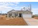 Charming single-story home boasts a well-manicured lawn and a two-car garage with a blue sky backdrop at 421 Sunforest Way, Conway, SC 29526
