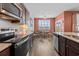 A modern kitchen with stainless steel appliances, dark wood cabinets and a view into the dining area at 421 Sunforest Way, Conway, SC 29526