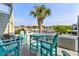 Balcony with teal outdoor furniture and a palm tree, overlooking the scenic marina at 4396 Baldwin Ave. # 34, Little River, SC 29566