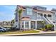 Inviting two-story condo featuring a bay window, complemented by well-maintained landscaping and a clear blue sky at 4396 Baldwin Ave. # 34, Little River, SC 29566