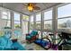 Bright sunroom features a ceiling fan, wicker furniture, and marina views from a wall of windows at 4396 Baldwin Ave. # 34, Little River, SC 29566