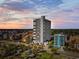 Stunning aerial view of a high-rise condominium building near the beach, with pools and beautiful landscaping at 5511 N Ocean Blvd. # 302, Myrtle Beach, SC 29577