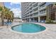 Outdoor pool area with lounge chairs and a high-rise building in the background at 5511 N Ocean Blvd. # 302, Myrtle Beach, SC 29577