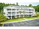 Three-story building with multiple units, ample parking, and landscaping at 6015 Catalina Dr. # 431, North Myrtle Beach, SC 29582