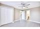 Bedroom with ceiling fan, gray walls, wood look flooring, white trim, and double door closet at 677 Tupelo Ln. # 301, Longs, SC 29568