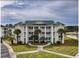 Condominium with balconies on each level, palm trees and walkway to entrance at 677 Tupelo Ln. # 301, Longs, SC 29568