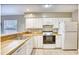 Well-lit kitchen with white cabinets, wood countertops, tile floors, and stainless sink at 677 Tupelo Ln. # 301, Longs, SC 29568