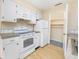White kitchen features stove, refrigerator, and pantry access at 7602 Porcher Dr. # C, Myrtle Beach, SC 29572