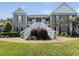 Inviting condo exterior with dual staircases, lush landscaping, and charming coastal architecture at 1109 Peace Pipe Ln. # 201, Myrtle Beach, SC 29579