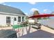 Back yard featuring an outdoor seating area with a red umbrella, covered pool, and green turf at 1209 Peyton Ct., Myrtle Beach, SC 29588