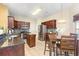 Eat-in kitchen featuring dark wood cabinetry, tile backsplash, stainless appliances, and tile flooring at 1209 Peyton Ct., Myrtle Beach, SC 29588