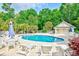 A community pool with lounge chairs, tables, mature landscaping, pool house and fence at 1209 Peyton Ct., Myrtle Beach, SC 29588