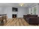 Cozy living room with fireplace, ceiling fan, hardwood floors, and a dark couch at 207 Townes Ct., Myrtle Beach, SC 29588