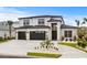 Two-story house with a three-car garage, stone accents, and landscaping at 215 82Nd Ave. N, Myrtle Beach, SC 29572