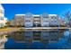 Condo building exterior reflects beautifully on the pond, set against a clear blue sky at 2268 Essex Dr. # L, Surfside Beach, SC 29575