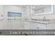 This Primary bath has a double vanity, a large mirror and a tiled shower with blue accents at 3545 Marion Ln., Murrells Inlet, SC 29576