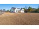 Expansive front lawn leads up to a charming home with a white board and batten exterior and a two-car garage door at 3647 Allentown Dr., Conway, SC 29526