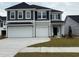 Two story home with gray siding, dark shutters, a two car garage, and concrete driveway at 4023 Bucolic Loop, Myrtle Beach, SC 29588