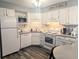 Cozy, bright kitchen with white cabinets, modern appliances, decorative back splash, and gray countertops for a beachy vibe at 4305 N Ocean Blvd. # 205, North Myrtle Beach, SC 29582