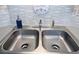 Stainless steel double sink with modern faucet fixtures and blue backsplash in a well-lit kitchen setting at 4305 N Ocean Blvd. # 205, North Myrtle Beach, SC 29582