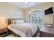 Comfortable bedroom with a cozy bed, plantation shutters, and a mounted television at 4609 Lightkeepers Way # 11J, Little River, SC 29566