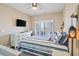 Inviting bedroom with a queen-sized bed, modern ceiling fan, and a light-filled window at 4609 Lightkeepers Way # 11J, Little River, SC 29566