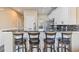 Kitchen island provides seating with elegant stools, showcasing white cabinetry, marble countertop, and stainless steel appliances at 4609 Lightkeepers Way # 11J, Little River, SC 29566