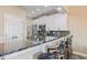 Kitchen with bar seating highlights white cabinets, stainless steel appliances, and striking black marble countertops at 4609 Lightkeepers Way # 11J, Little River, SC 29566