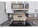Updated kitchen showcasing stainless steel microwave and oven with elegant dark marble countertops and backsplash at 4609 Lightkeepers Way # 11J, Little River, SC 29566