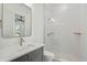 Bright bathroom featuring a shower with vertical tiles, grey cabinets, and gold fixtures at 477 Starlit Way, Myrtle Beach, SC 29579