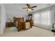 Bedroom features a wooden bed, matching dresser, neutral carpet, and a ceiling fan with lighting at 5314 Abbey Park Loop, Myrtle Beach, SC 29579