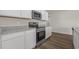 Well-lit kitchen features stainless appliances, granite countertops, and white cabinets at 57 Cape Point Dr., Conway, SC 29527